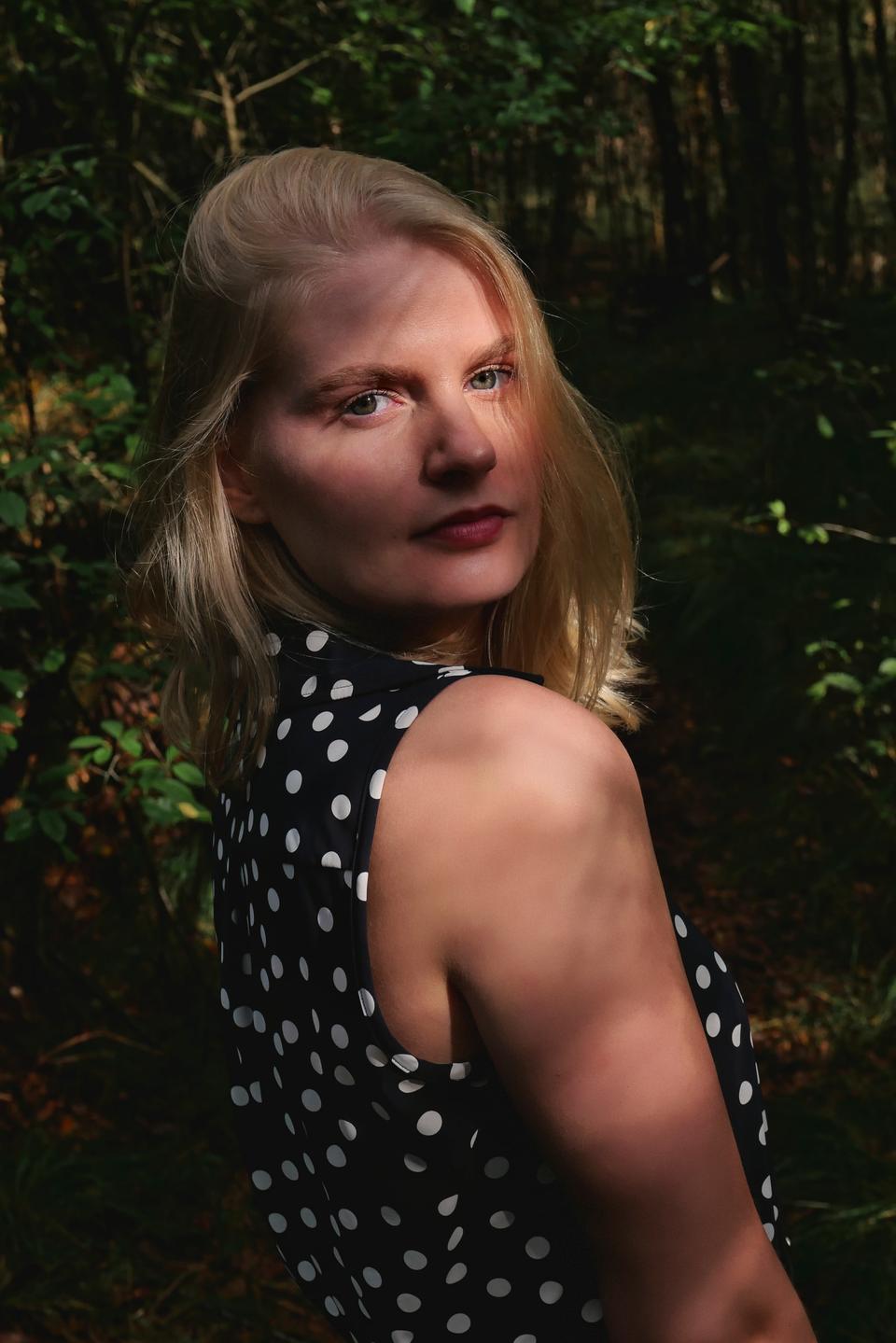 A woman in a polka dot dress looking over her shoulder